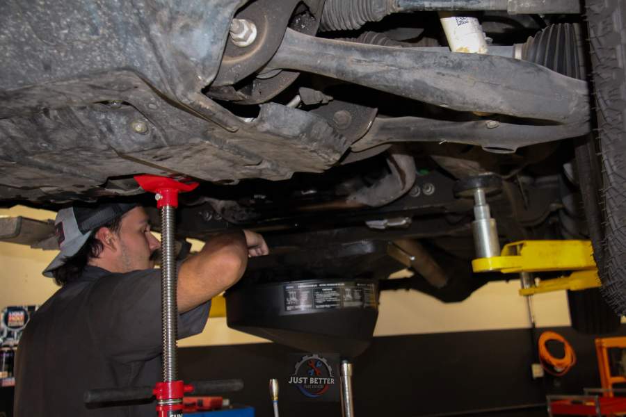 Technician servicing the underside of a fleet vehicle