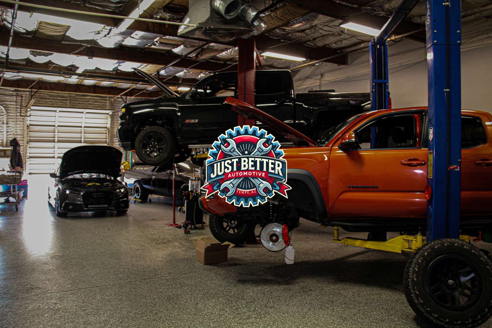 Inside the Just Better shop with vehicles on lifts